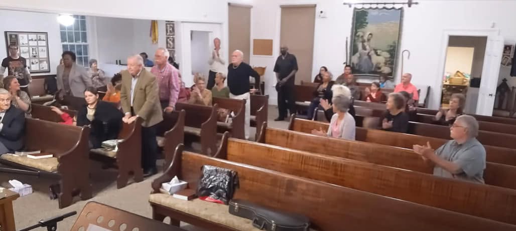 The Elko Baptist congregation standing and clapping together during a Sunday worship service