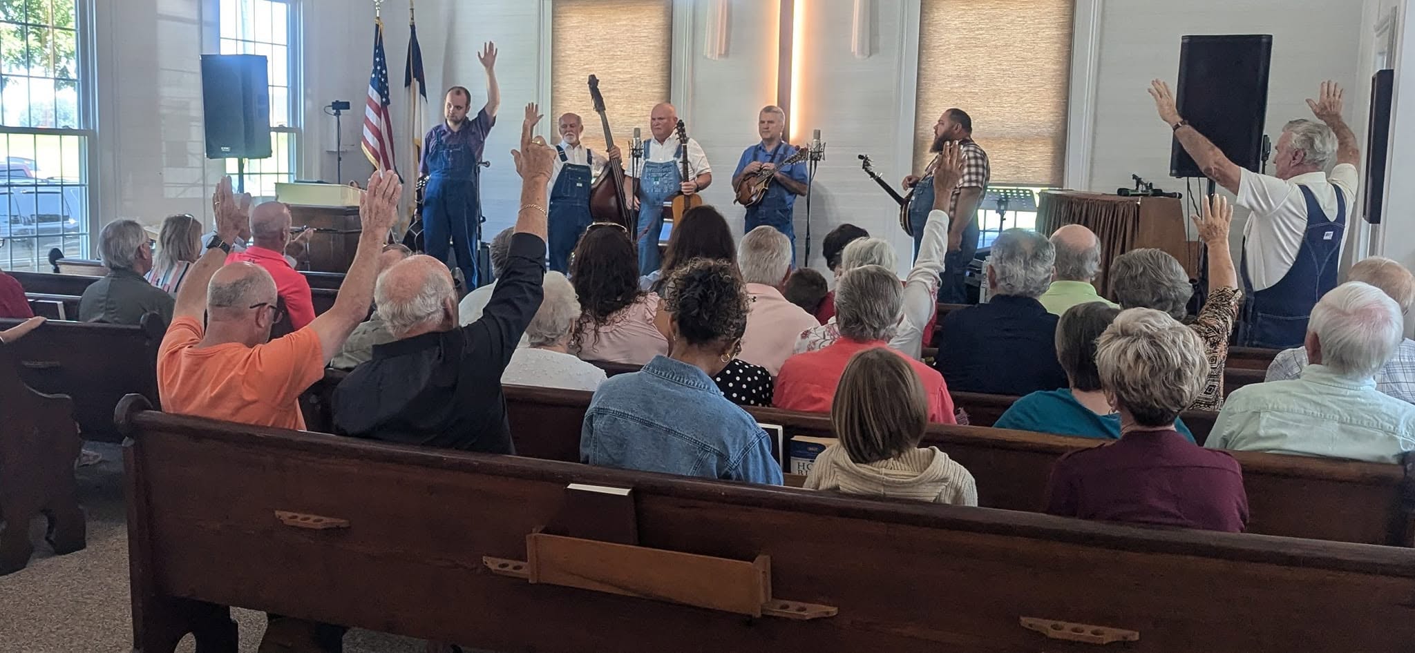 Inside the Elko Baptist Church sanctuary during worship, with the congregation and worship team gathered beneath the cross